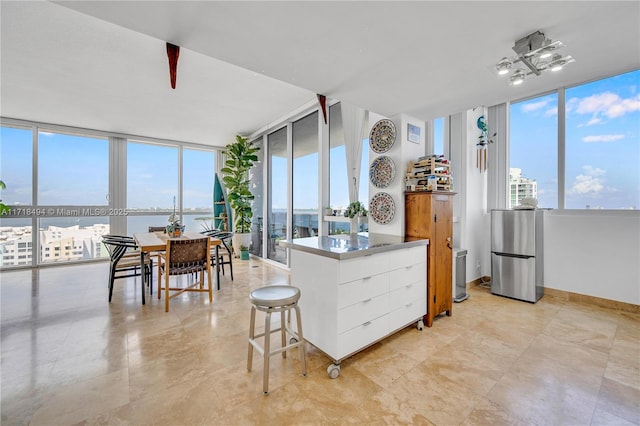 kitchen featuring white cabinets, expansive windows, and a healthy amount of sunlight