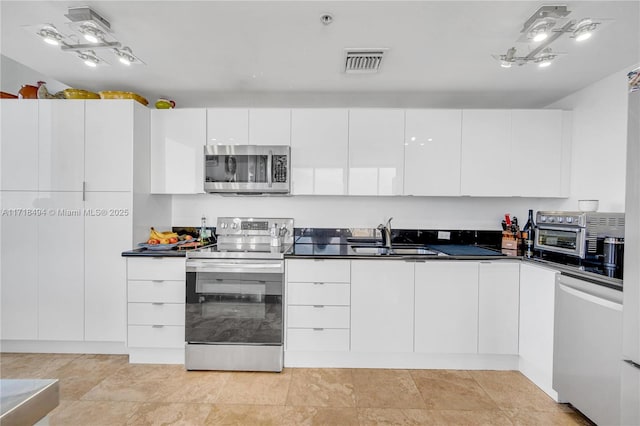 kitchen featuring white cabinets, appliances with stainless steel finishes, and sink