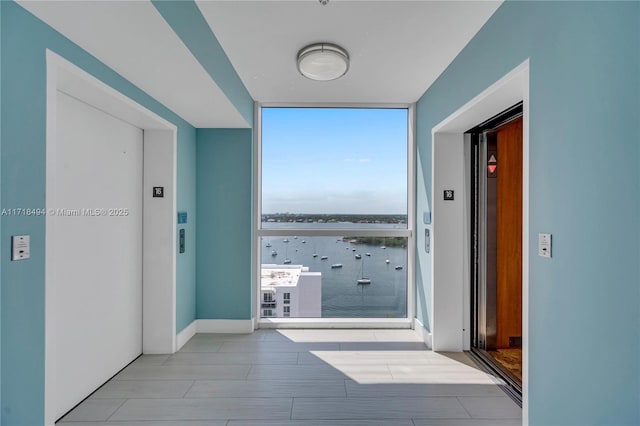 corridor featuring floor to ceiling windows and elevator