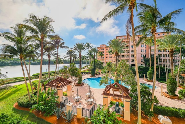 view of swimming pool with a patio area and a water view