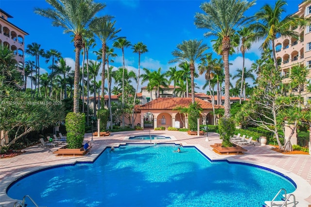 view of pool featuring a hot tub and a patio area