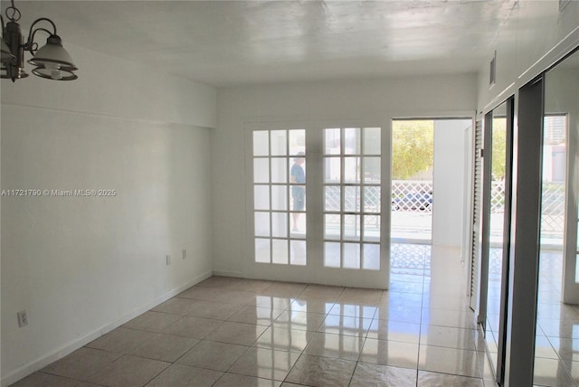 unfurnished room featuring light tile patterned flooring and a chandelier