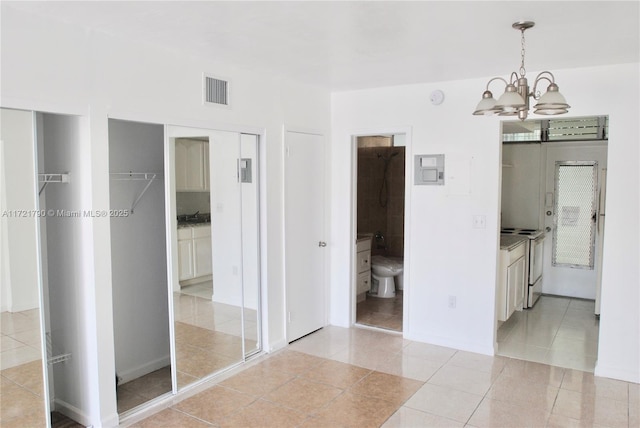 interior space featuring tile patterned floors and a chandelier