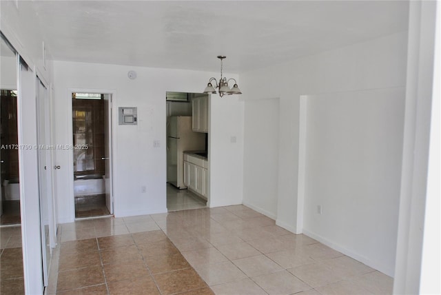 unfurnished room featuring light tile patterned floors and a chandelier