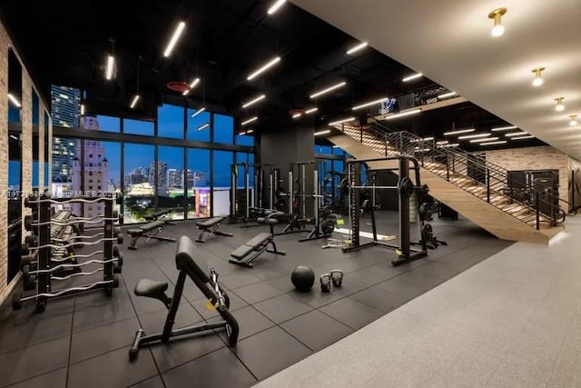 exercise room with a high ceiling and a wall of windows