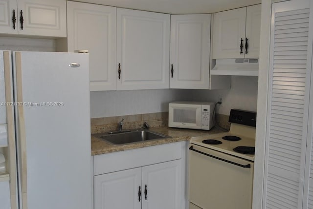 kitchen featuring sink, white appliances, and white cabinetry