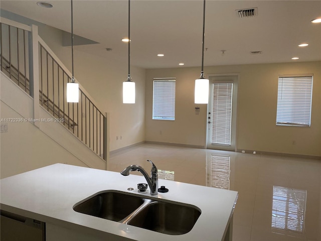 kitchen featuring tile patterned floors, sink, a kitchen island, and pendant lighting