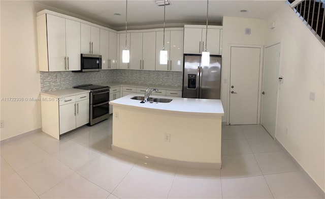 kitchen featuring pendant lighting, sink, white cabinetry, a kitchen island with sink, and stainless steel appliances