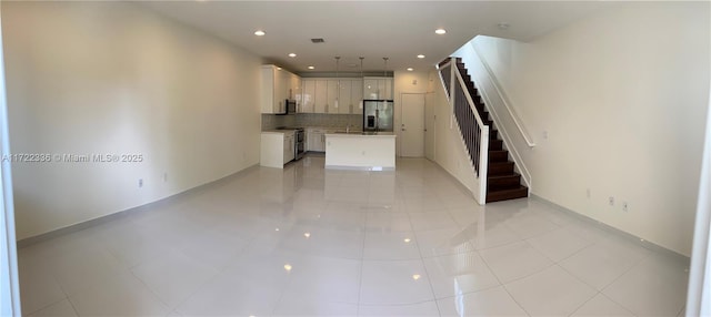 unfurnished living room with light tile patterned floors and sink