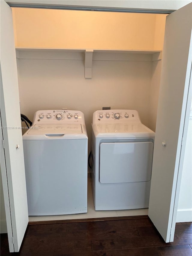 clothes washing area with washer and clothes dryer and dark hardwood / wood-style floors