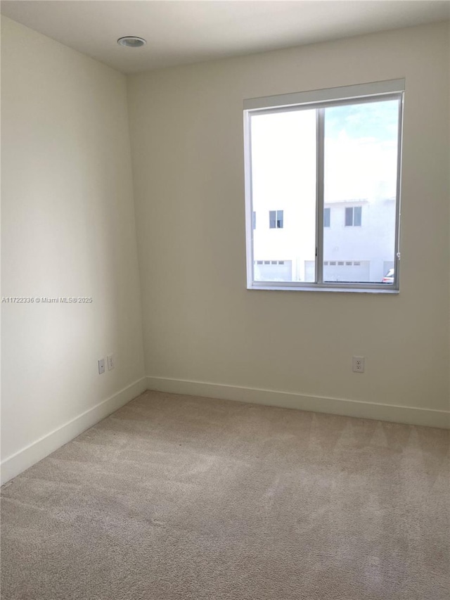 spare room featuring light colored carpet