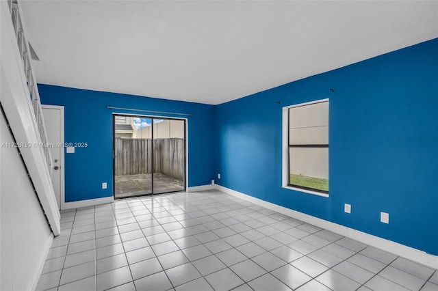 spare room with light tile patterned floors and a wealth of natural light