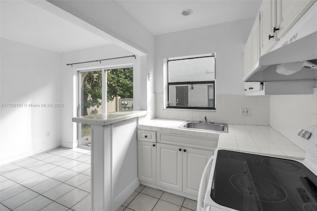 kitchen with tasteful backsplash, sink, tile countertops, and white cabinetry