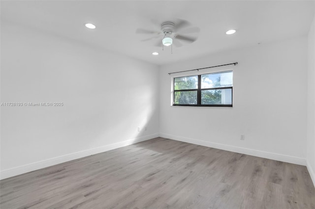 empty room with ceiling fan and light hardwood / wood-style floors