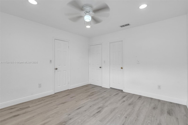 spare room with light wood-type flooring and ceiling fan