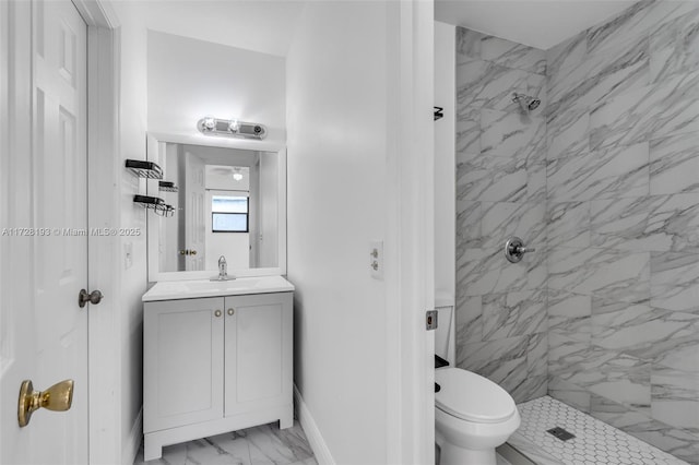 bathroom featuring toilet, vanity, and tiled shower