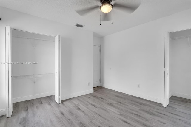 unfurnished bedroom with light wood-type flooring, ceiling fan, and a textured ceiling