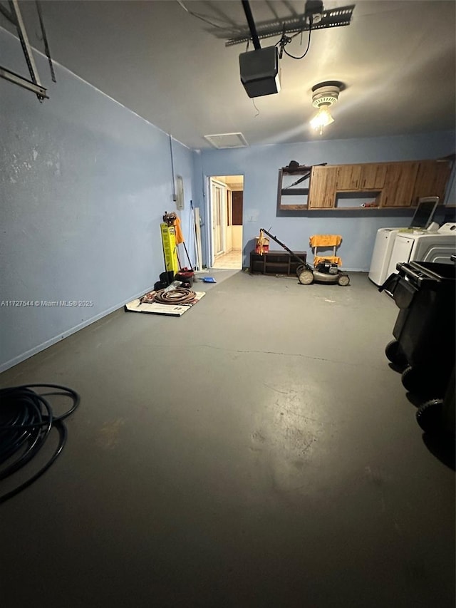 garage featuring washing machine and dryer and a garage door opener