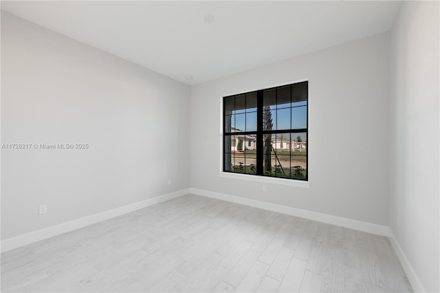 empty room featuring light wood-style flooring and baseboards