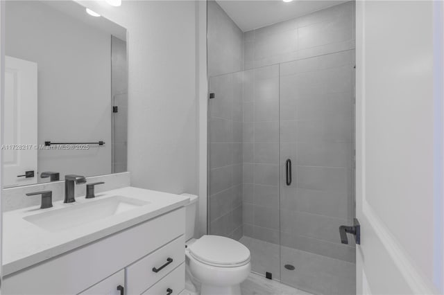 bathroom featuring a stall shower, vanity, and toilet