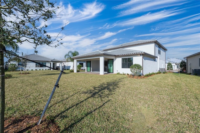 back of property featuring a lawn and a tiled roof