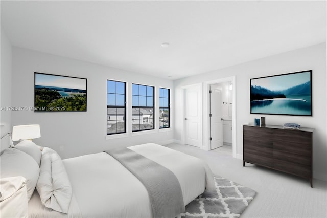 bedroom with baseboards and light colored carpet