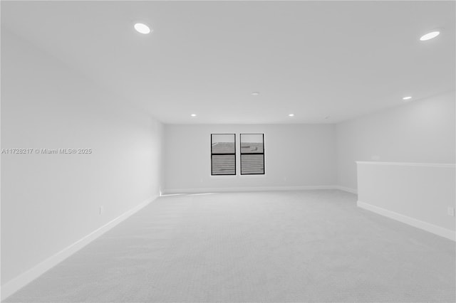 empty room featuring baseboards, light carpet, and recessed lighting