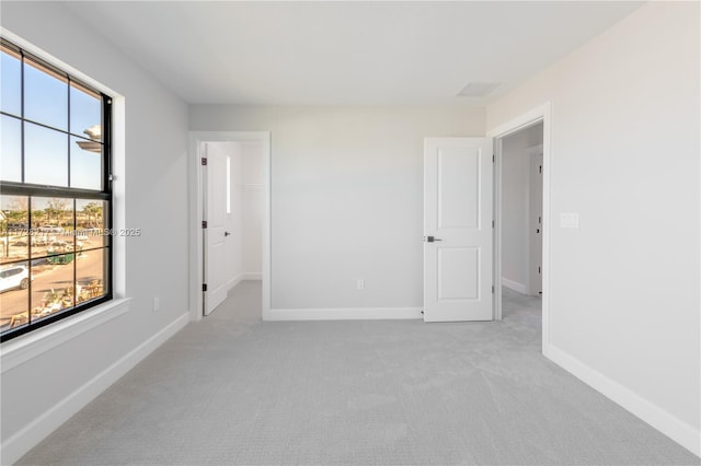 carpeted empty room featuring a healthy amount of sunlight and baseboards