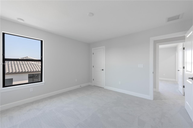 unfurnished room featuring light carpet, baseboards, and visible vents