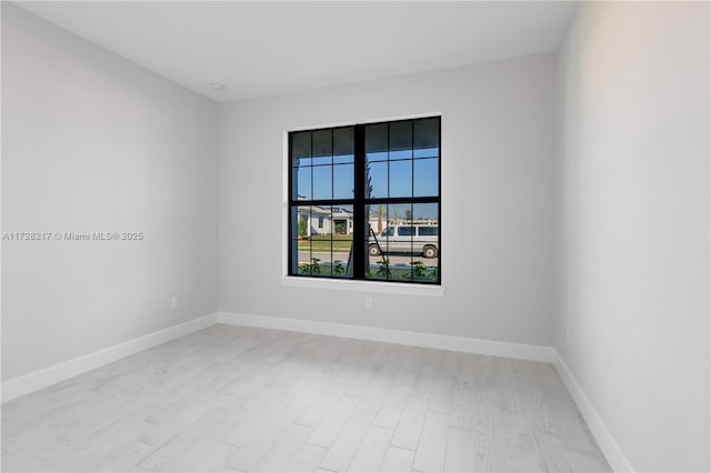 empty room with light wood-style floors and baseboards