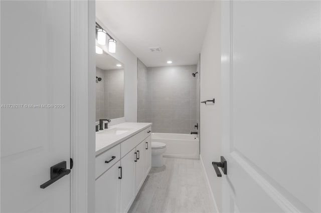 full bathroom with shower / washtub combination, visible vents, toilet, vanity, and wood finished floors