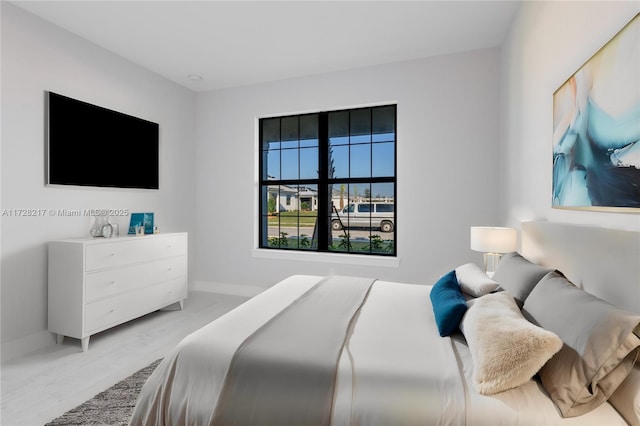 bedroom with light wood-style flooring and baseboards