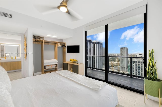 bedroom with connected bathroom, floor to ceiling windows, access to exterior, ceiling fan, and light tile patterned floors