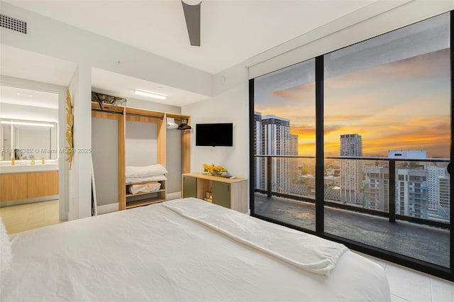 bedroom featuring ceiling fan, ensuite bathroom, and access to outside