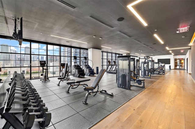 workout area with a wall of windows and hardwood / wood-style floors