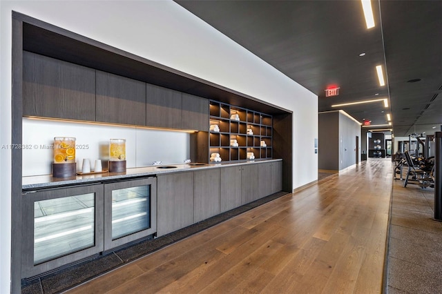 bar with built in shelves and wood-type flooring