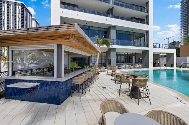 view of pool featuring a patio area and exterior bar