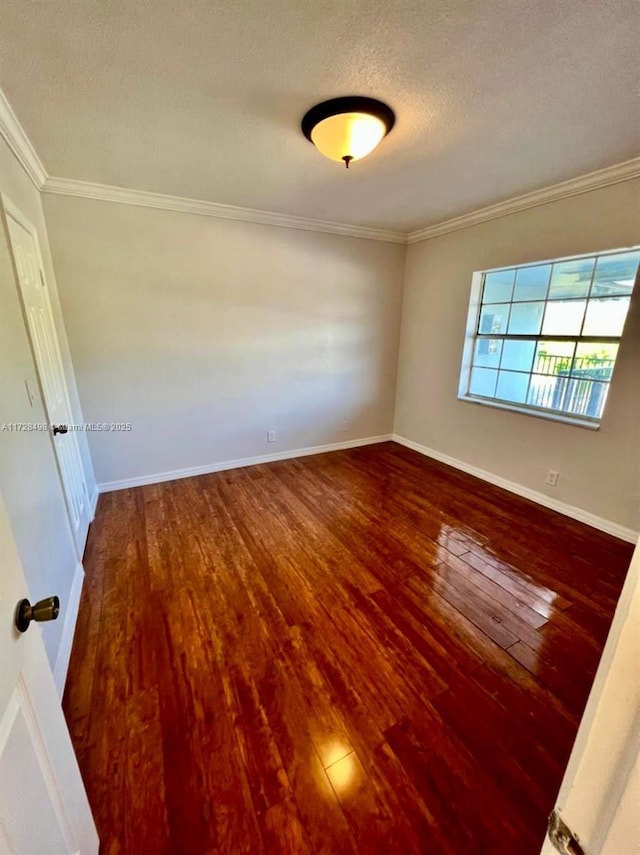 empty room featuring a textured ceiling, crown molding, and hardwood / wood-style floors