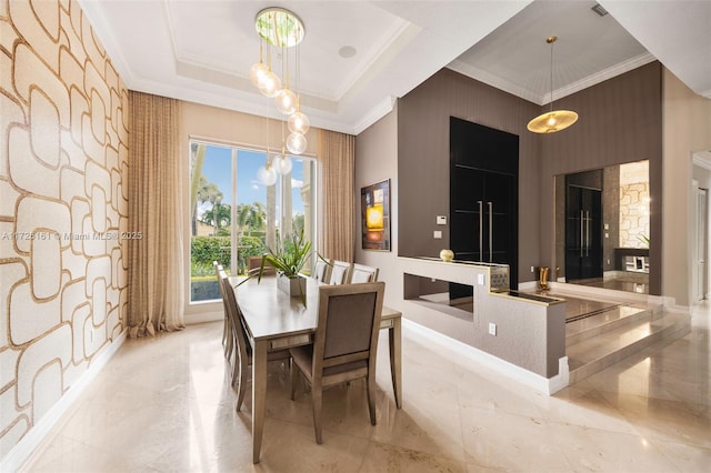 dining room featuring wood walls, a tray ceiling, ornamental molding, and a notable chandelier