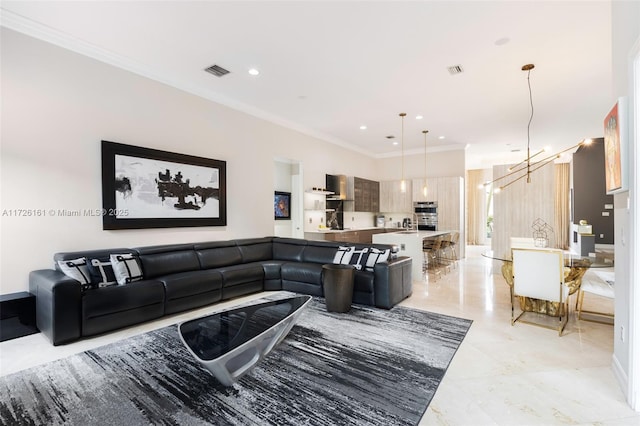 living room with a notable chandelier and crown molding