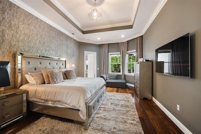 bedroom with dark wood-type flooring, a tray ceiling, and ornamental molding