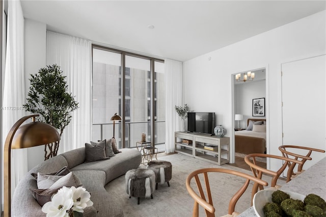 carpeted living room featuring an inviting chandelier and a wall of windows