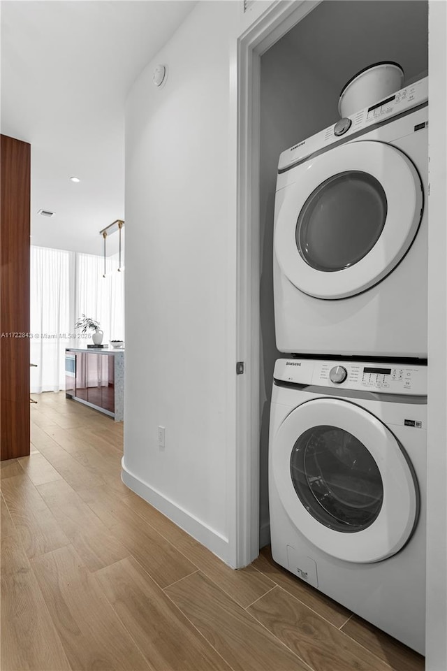 washroom featuring stacked washer and clothes dryer