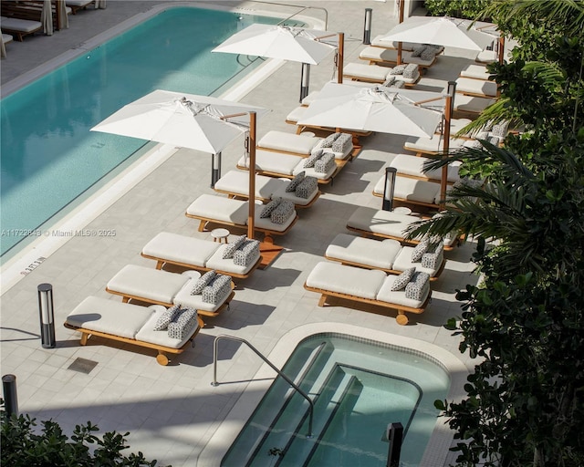 view of swimming pool featuring a patio area and a jacuzzi