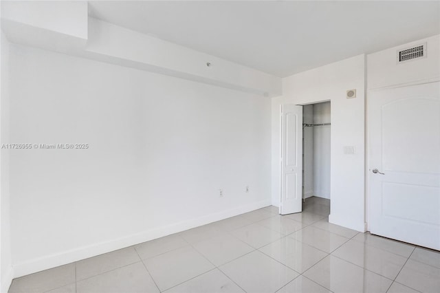 unfurnished bedroom featuring light tile patterned floors and a closet