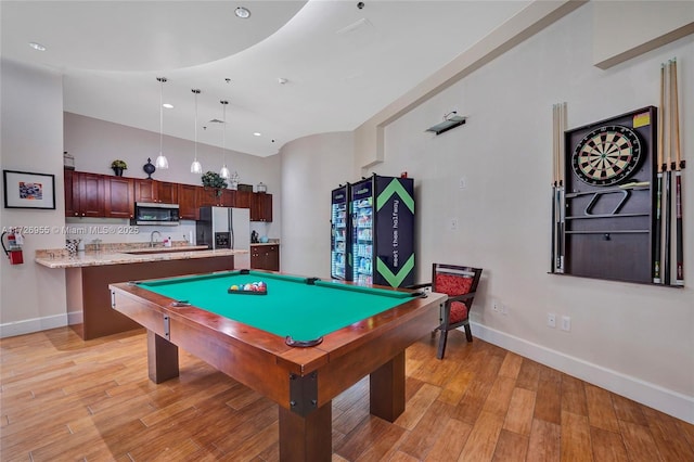 game room with a high ceiling, pool table, light hardwood / wood-style flooring, and sink