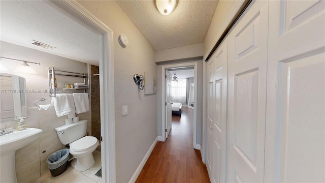 hallway with wood-type flooring and a textured ceiling