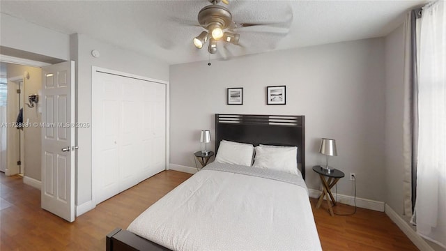 bedroom featuring ceiling fan, a textured ceiling, hardwood / wood-style flooring, and a closet