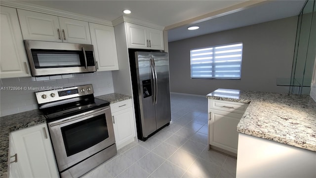 kitchen with tasteful backsplash, stainless steel appliances, white cabinetry, and light stone counters