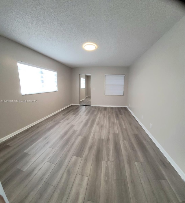 empty room with a textured ceiling and hardwood / wood-style flooring